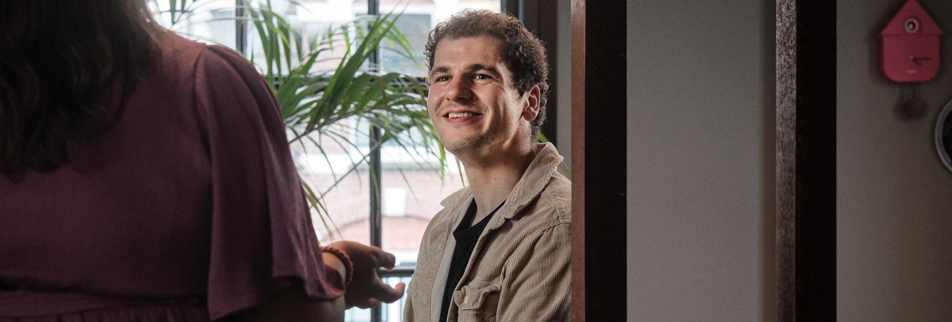 Timing intercedent kijkt warm naar collega tijdens gesprek over werk.